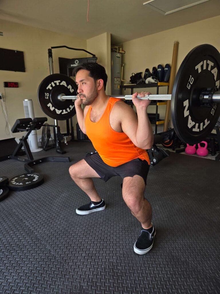 Barbell Squat in Garage Home Gym for Lower Body Strength Person performing a barbell squat in a garage home gym.
