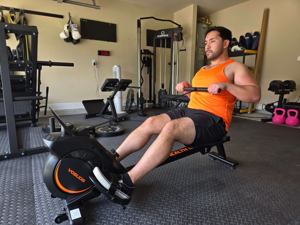 Rowing Machine Cardio Workout in Garage Home Gym Person using a rowing machine for cardio workout in a garage home gym.