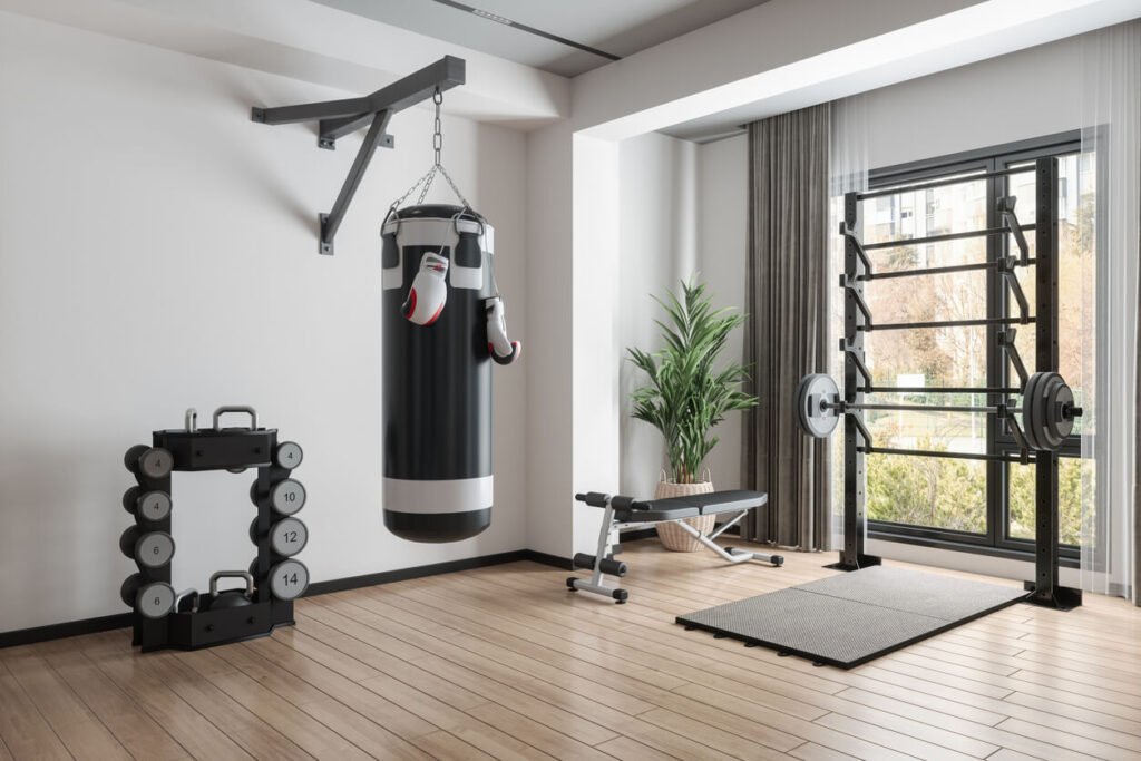 Modern home gym with a punching bag, dumbbells, weight rack, and bench press setup.