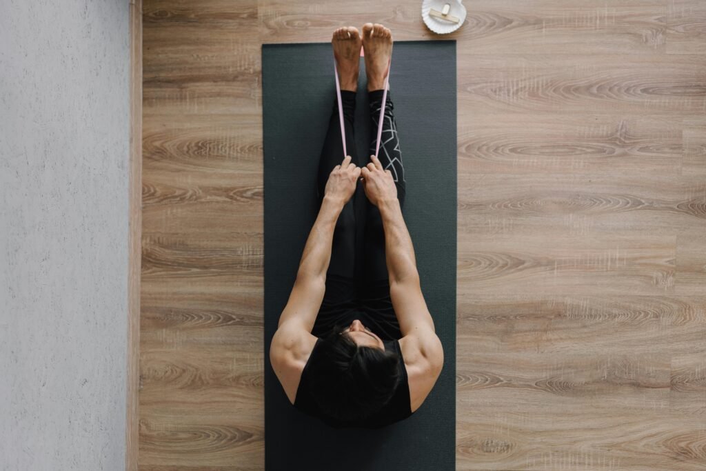 Person performing a seated row with a resistance band on a yoga mat
